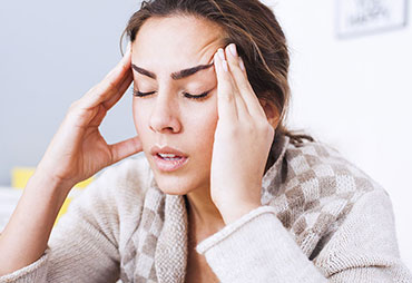 Woman sufferinf from headaches in need of Sports Injury Care