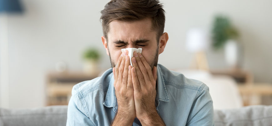 Man suffering at home with severe allergies